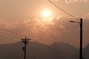 an early morning sun over the mountains, red with the smoke from nearby fires